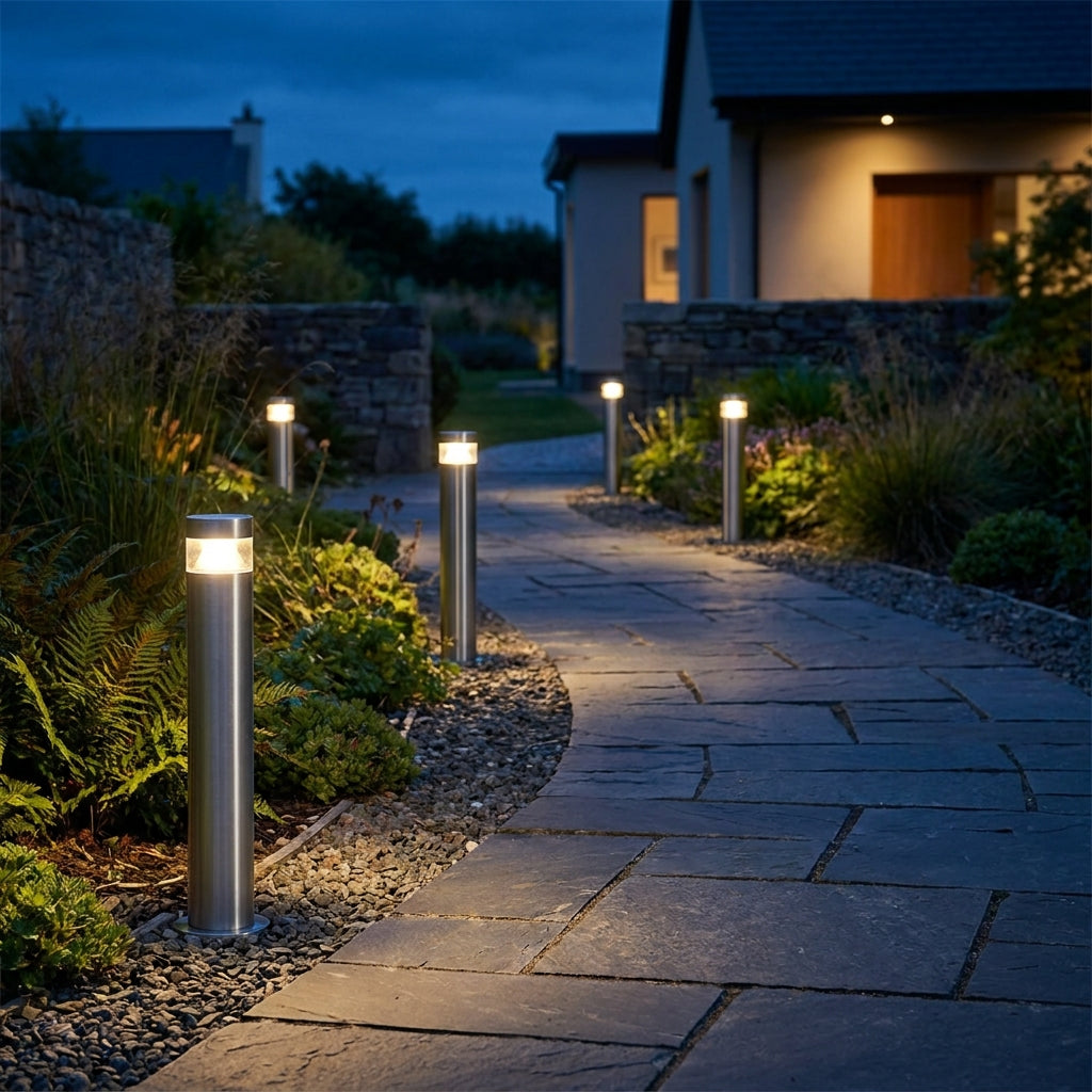 Stainless steel bollard lights lining a garden path and driveway at dusk