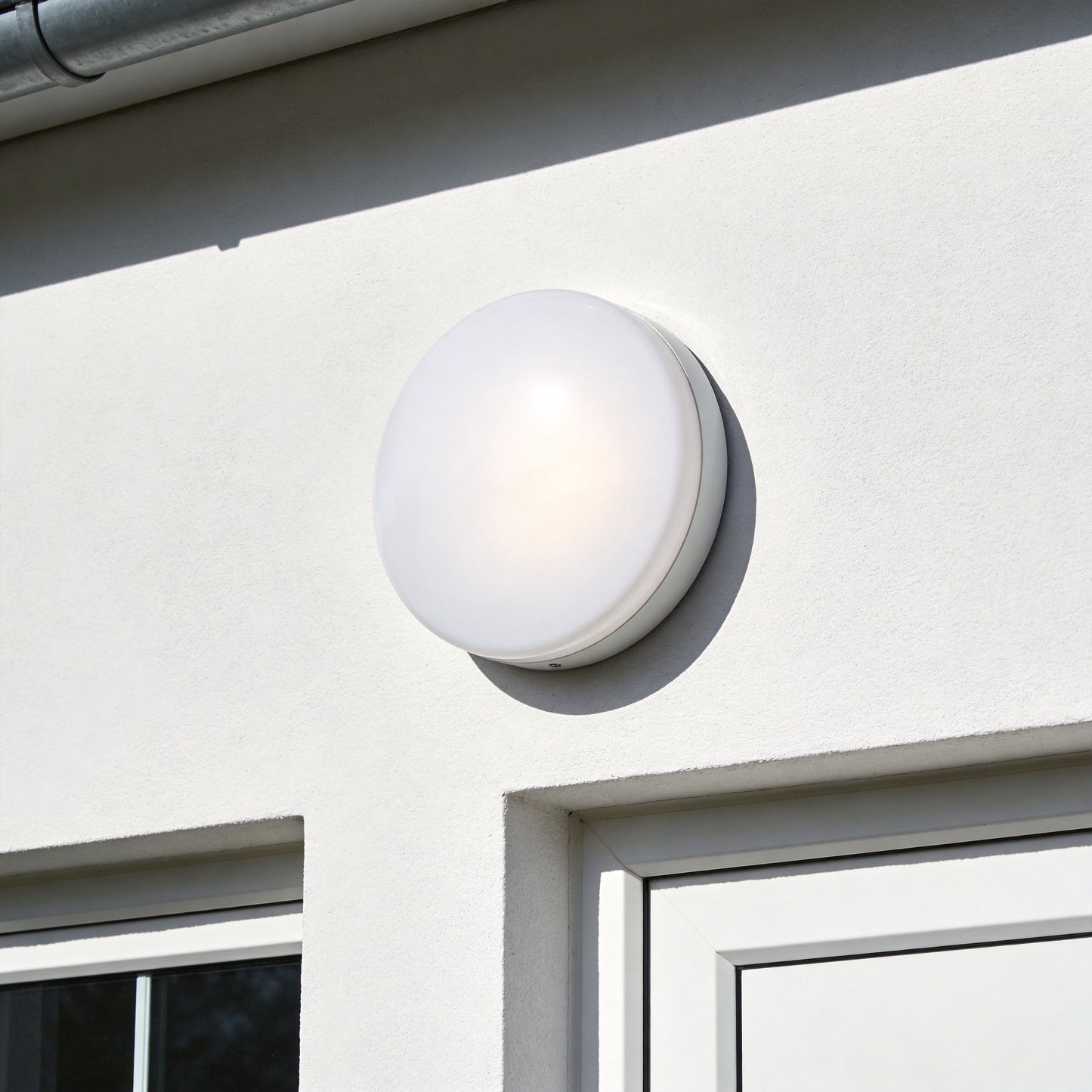 Round white LED bulkhead light mounted on exterior wall