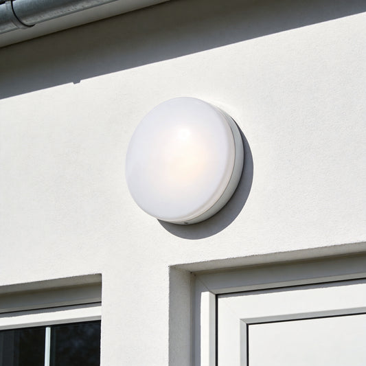 Round white LED bulkhead light mounted on exterior wall