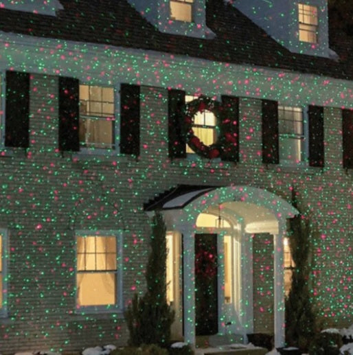 Red and green laser lights decorating a house exterior for Christmas
