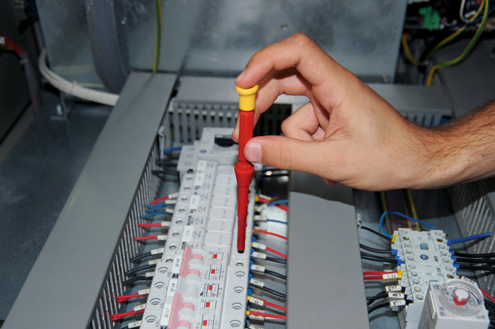 Heytec VDE insulated screwdriver working inside a breaker panel—safe 1000V tool for electricians.