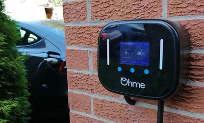 Ohme Home Pro 7.4kW tethered EV charger mounted on a house wall charging an electric car